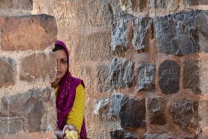 Una mujer se asoma cautelosa hacia la explanada central de la Jama Masjid