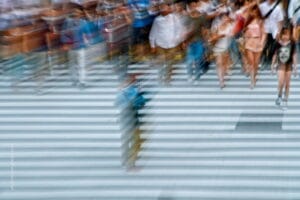 El siempre cambiante cruce de Shibuya en Tokio y dos turistas que se apresuran a tomarle fotos a la multitud